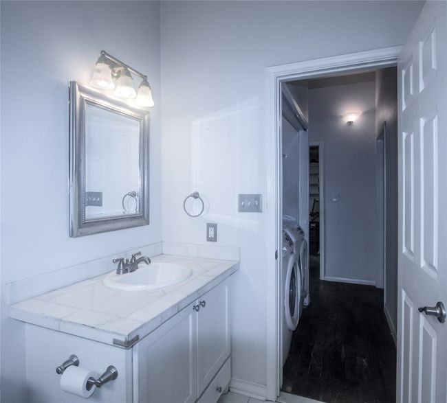 Bathroom featuring washing machine and dryer, vanity, and wood finished floors | Image 15