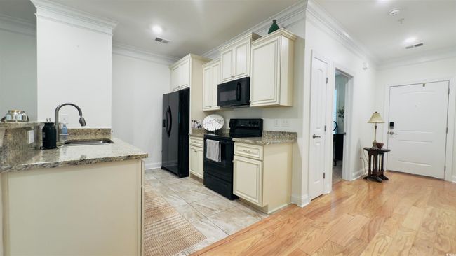 Kitchen featuring black appliances, crown molding, light stone counters, and recessed lighting | Image 14