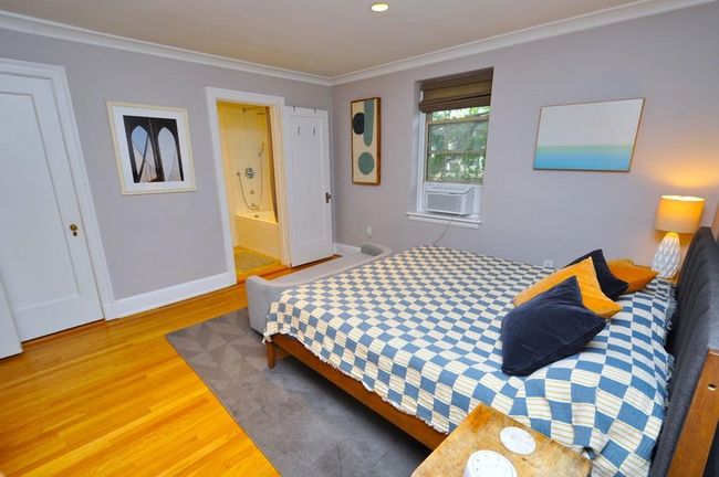 Corner main bedroom has hardwood floor and access to the renovated bathroom. The bedroom is 14'-7" x 13'-2". | Image 20