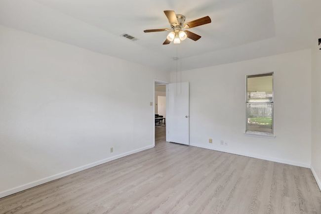 Empty room featuring light wood-style flooring, ceiling fan, and baseboards | Image 12