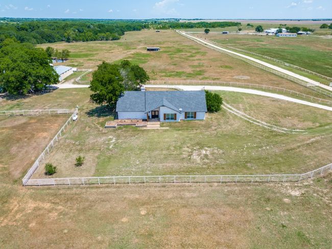 Acreage is partially bordered with a pipe fence with an interior fence around the homestead area. Extensive fenced pens for animals on the west side of the second barn. | Image 36