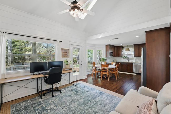 Office area with dark wood-type flooring, a ceiling fan, wood walls, and high vaulted ceiling | Image 7