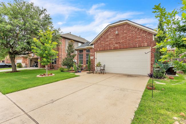 View of front of house featuring brick siding, a garage, concrete driveway, and a front lawn | Image 11