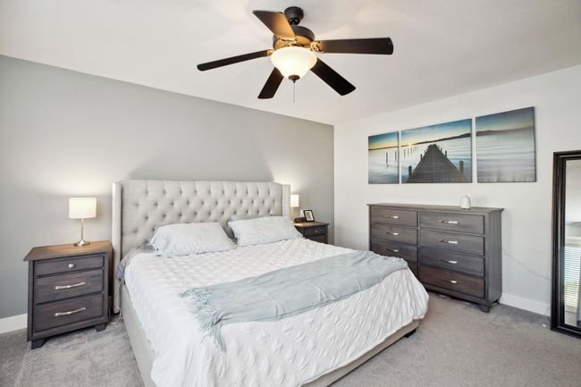 Bedroom with baseboards, a ceiling fan, and light carpet | Image 17