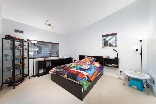 Carpeted bedroom featuring baseboards, vaulted ceiling, and track lighting | Image 24