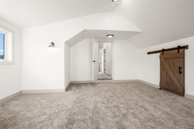 Bonus room featuring carpet, vaulted ceiling, and a barn door | Image 28