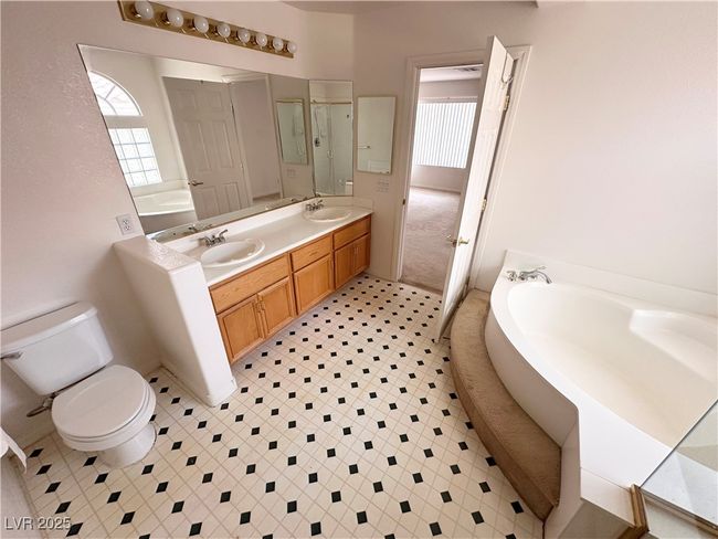 Bathroom featuring toilet, a garden tub, plenty of natural light, and double vanity | Image 26