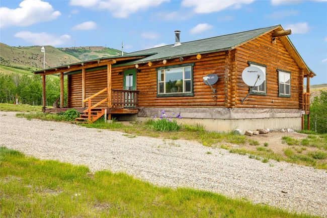Cabin featuring log siding, a mountain view, and covered porch | Image 25