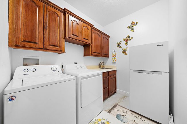 Functional laundry room with cabinets for storage | Image 36