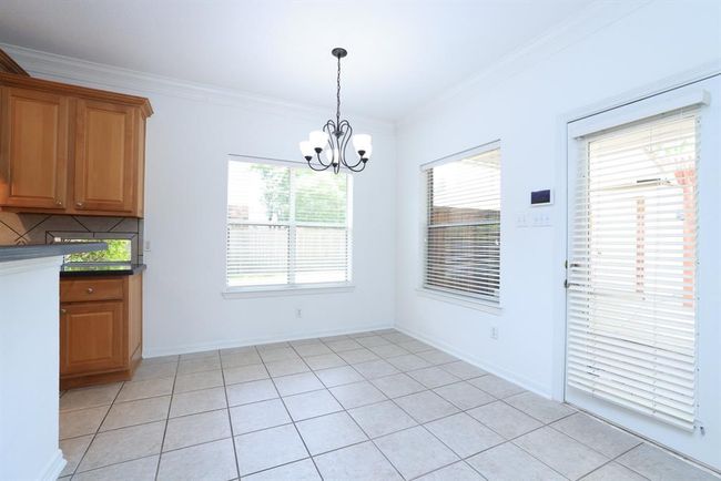 Breakfast nook opens to family room and gourmet kitchen. Doorway leads to covered patio | Image 14