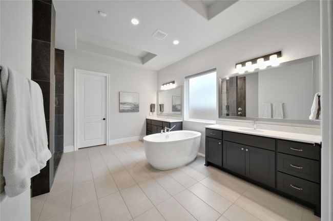 Spa-like bathroom with dual vanities, soaking tub, and a glass-enclosed shower. | Image 26