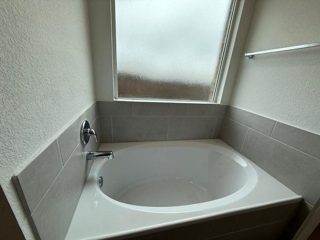 Full bathroom featuring a garden tub and a textured wall | Image 27