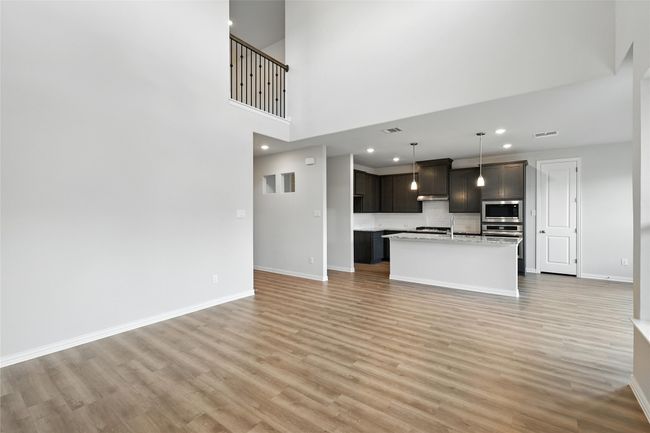 Unfurnished living room with light wood-type flooring, recessed lighting, and a towering ceiling | Image 12