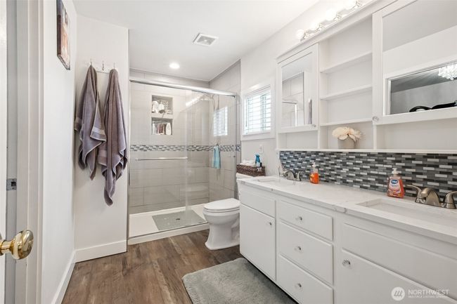 Stunning updated primary bathroom with dual vanity, beautiful tile backsplash, large tile surround shower | Image 17