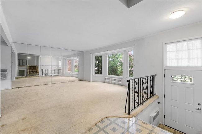 Entrance foyer featuring radiator, carpet, and plenty of natural light | Image 4