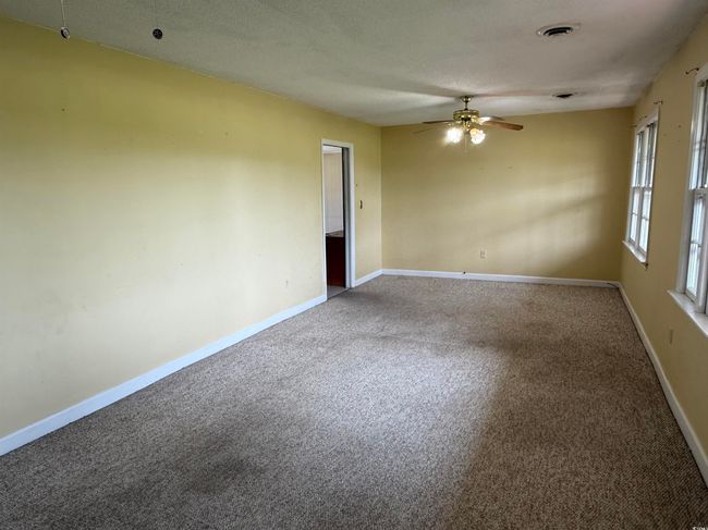 Carpeted empty room featuring ceiling fan and baseboards | Image 6