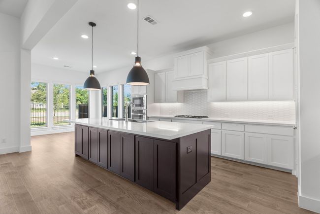 Kitchen with gas cooktop, light countertops, backsplash, white cabinets, and recessed lighting | Image 25