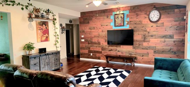 Living area with wooden walls, wood finished floors, ceiling fan, and an accent wall | Image 7