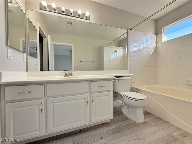 Full bath with vanity, wood finished floors, visible vents, toilet, and shower / bathtub combination | Image 33