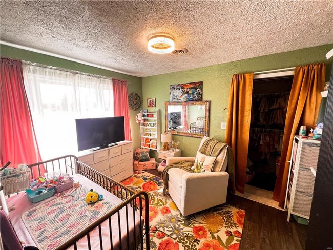 Living room featuring visible vents, a textured wall, a textured ceiling, and wood finished floors | Image 18