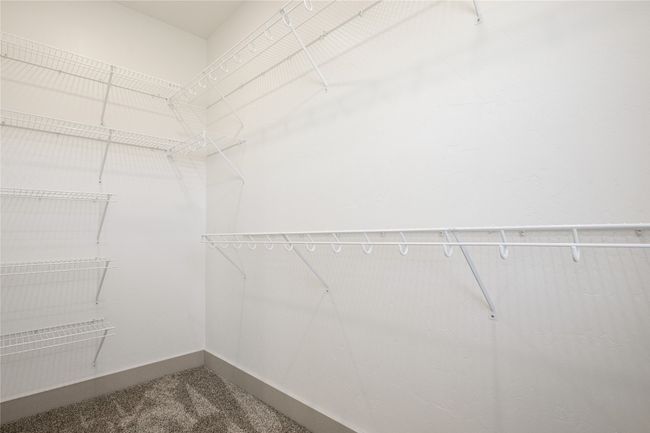 Spacious closet featuring dark carpet | Image 37