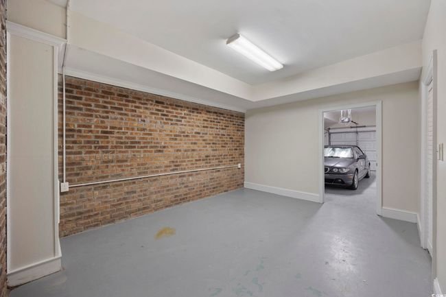Basement featuring brick wall and baseboards | Image 37
