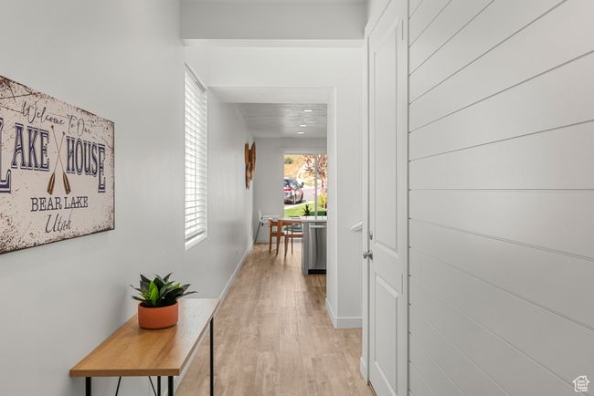 Corridor with light wood-style flooring and baseboards | Image 4