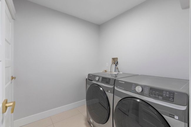 Laundry area featuring light tile patterned floors, separate washer and dryer, laundry area, and baseboards | Image 20