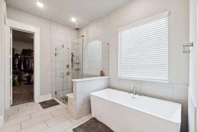 Full bathroom featuring a shower stall, a freestanding tub, a spacious closet, tile patterned floors, and recessed lighting | Image 21