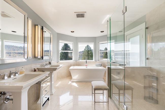 Full bathroom featuring tile walls, tile patterned flooring, a freestanding bath, a stall shower, and a wainscoted wall | Image 19