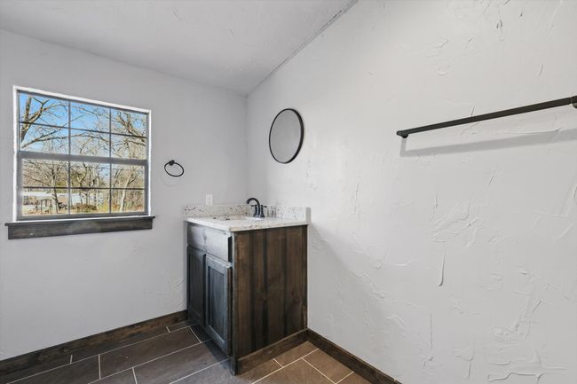 Bathroom featuring baseboards, vanity, and vaulted ceiling | Image 21