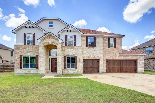 Front of home with brick and stone and 3 car garage | Image 32