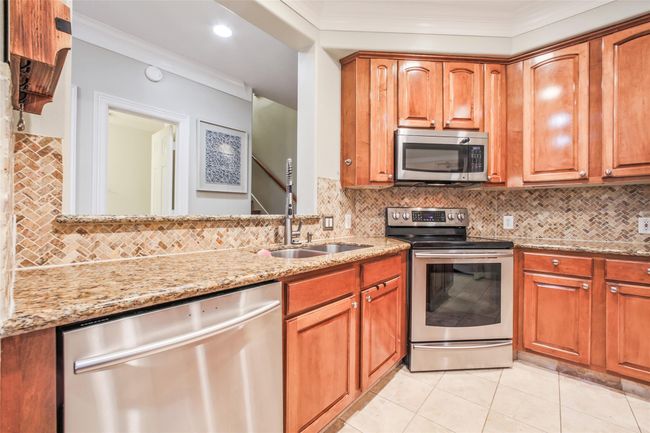 Spacious kitchen features granite countertops and stainlesss appliances. | Image 10