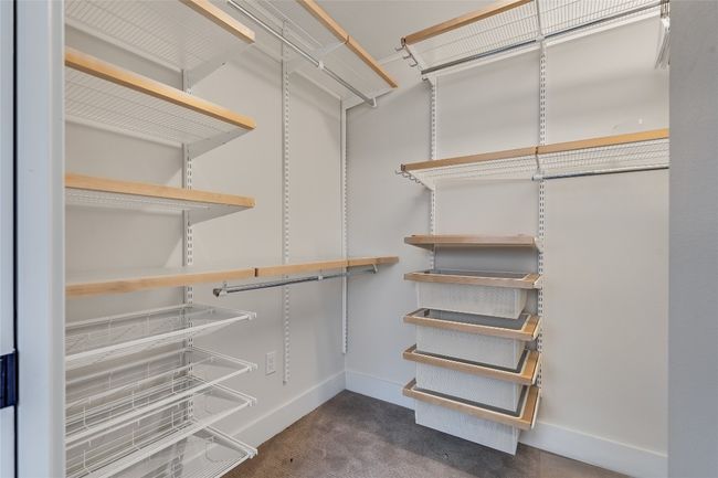 Large walk-in primary suite closet with ample storage. | Image 27