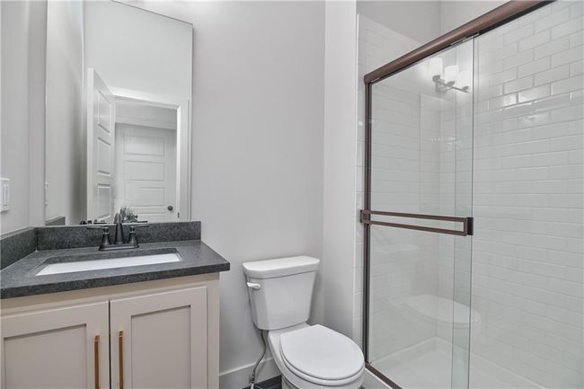 Bathroom featuring vanity, toilet, and a shower with door | Image 32