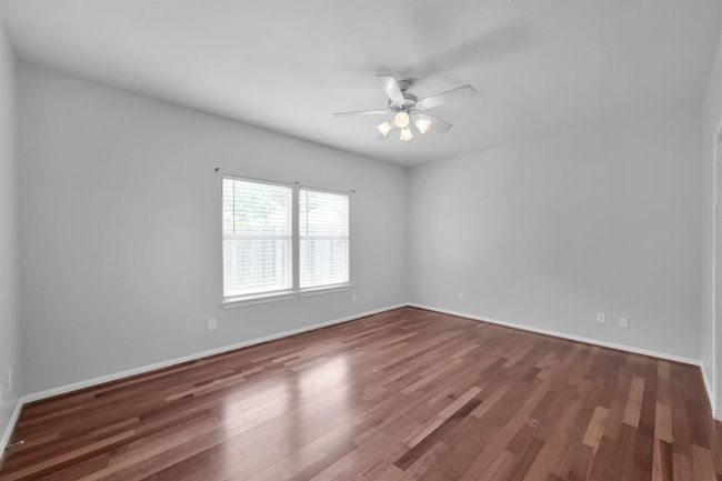 The large 16 x 12 primary bedroom has been updated with hardwood floors, adding an elegant look and feel. | Image 17