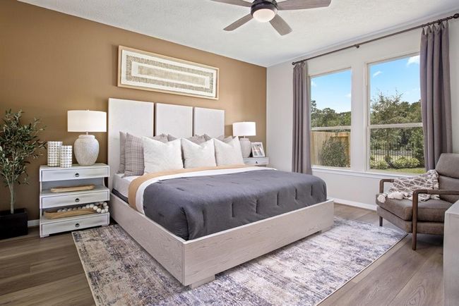 Come and unwind after a long day in this magnificent primary suite! This spacious room features vinyl plank flooring, custom paint, high ceilings, ceiling fan, and large windows! | Image 6