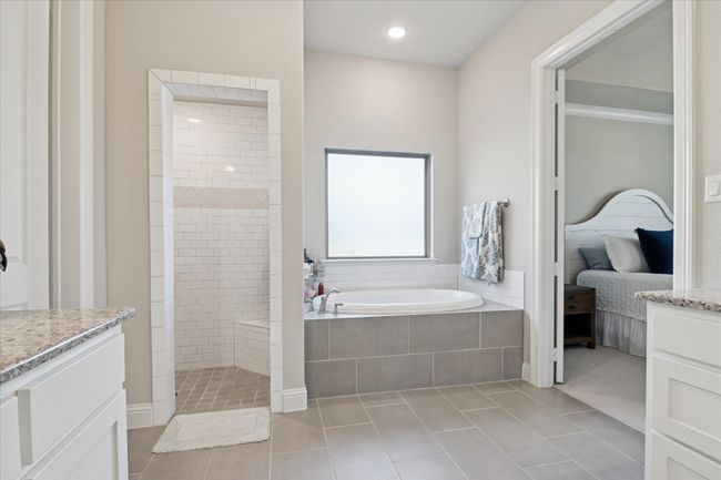 Ensuite bathroom featuring ensuite bathroom, tile patterned flooring, walk in shower, and a bath | Image 15
