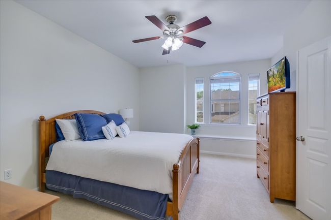 Bedroom with light colored carpet and a ceiling fan | Image 9