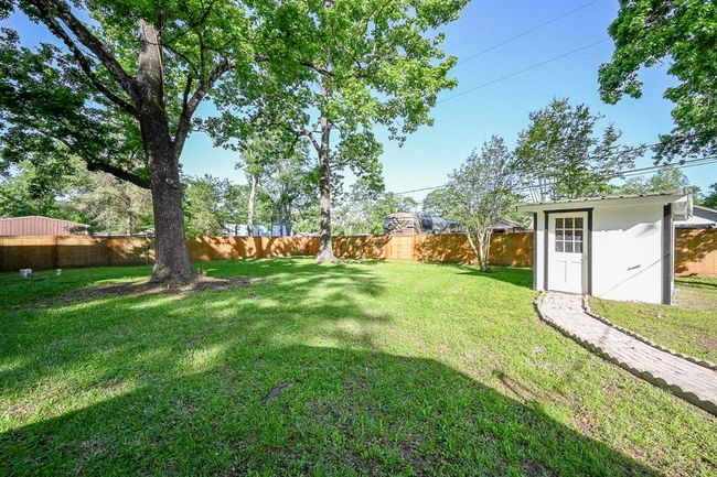 Mature trees provide much needed shade during the warm months. A brick path leads from the home to the well house. | Image 29
