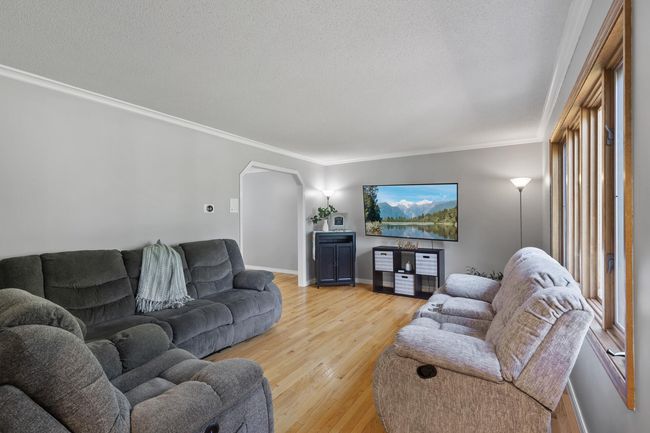 Inviting living room featuring beautiful hardwood floors, a picturesque window, and plenty of space to relax and unwind. | Image 6