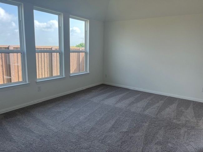Empty room featuring plenty of natural light and dark carpet | Image 4