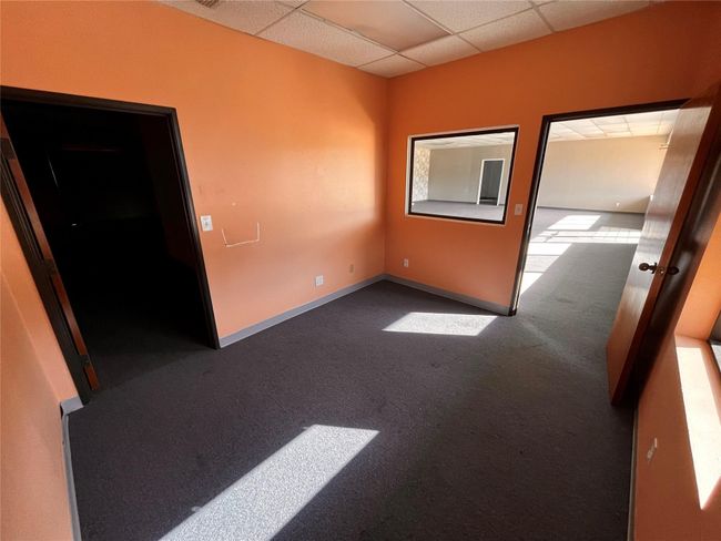 Carpeted empty room featuring a drop ceiling and baseboards | Image 8