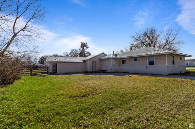 Back of property with a chimney, a lawn, and metal roof | Image 19