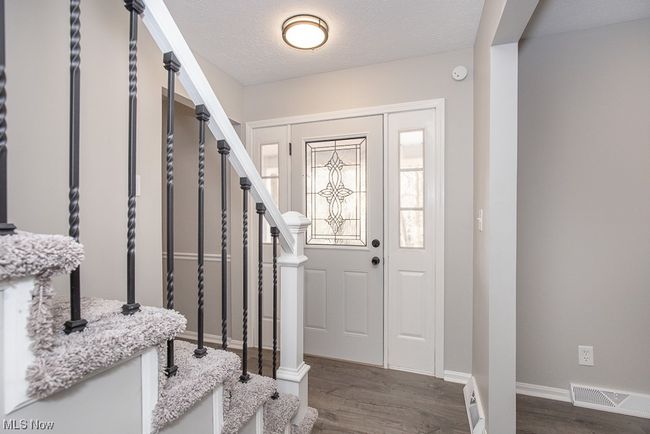 Foyer entrance featuring dark wood-type flooring and a textured ceiling | Image 24