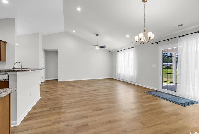 Unfurnished living room with recessed lighting, light wood-type flooring, ceiling fan, a chandelier, and baseboards | Image 29