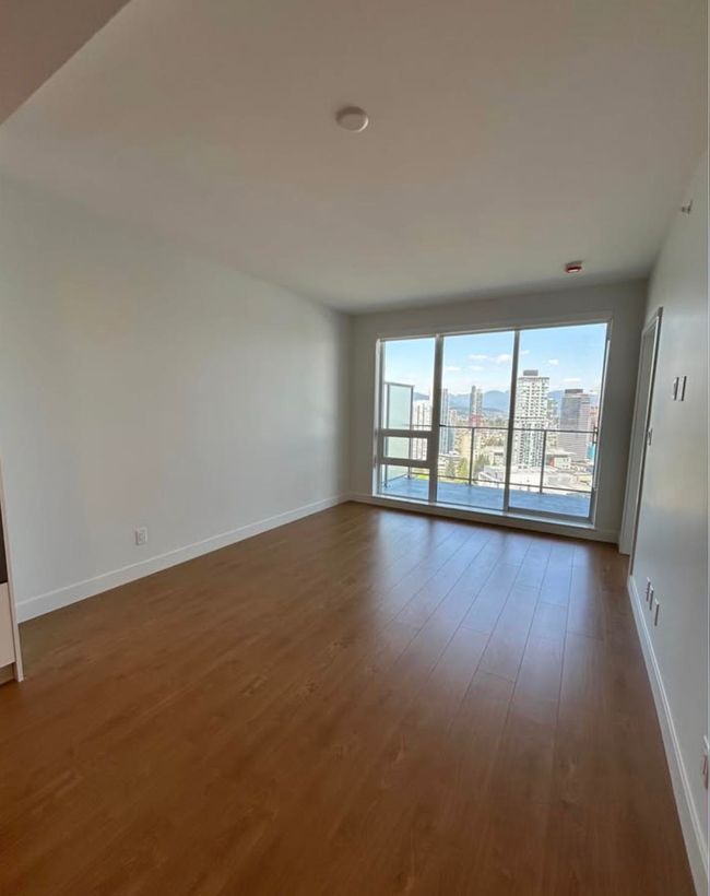 Unfurnished room featuring dark wood finished floors, baseboards, and a view of city | Image 11