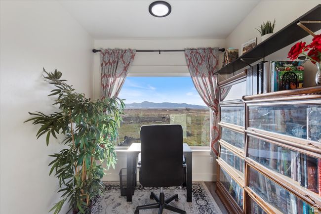 Office featuring a mountain view, baseboards, and wood finished floors | Image 19