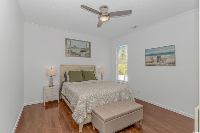 Bedroom with wood finished floors, baseboards, ceiling fan, and crown molding | Image 18