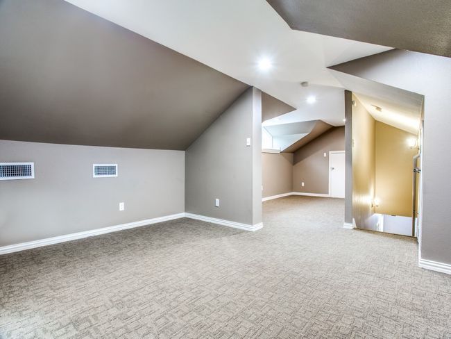 Additional living space featuring visible vents, baseboards, carpet flooring, and vaulted ceiling | Image 15